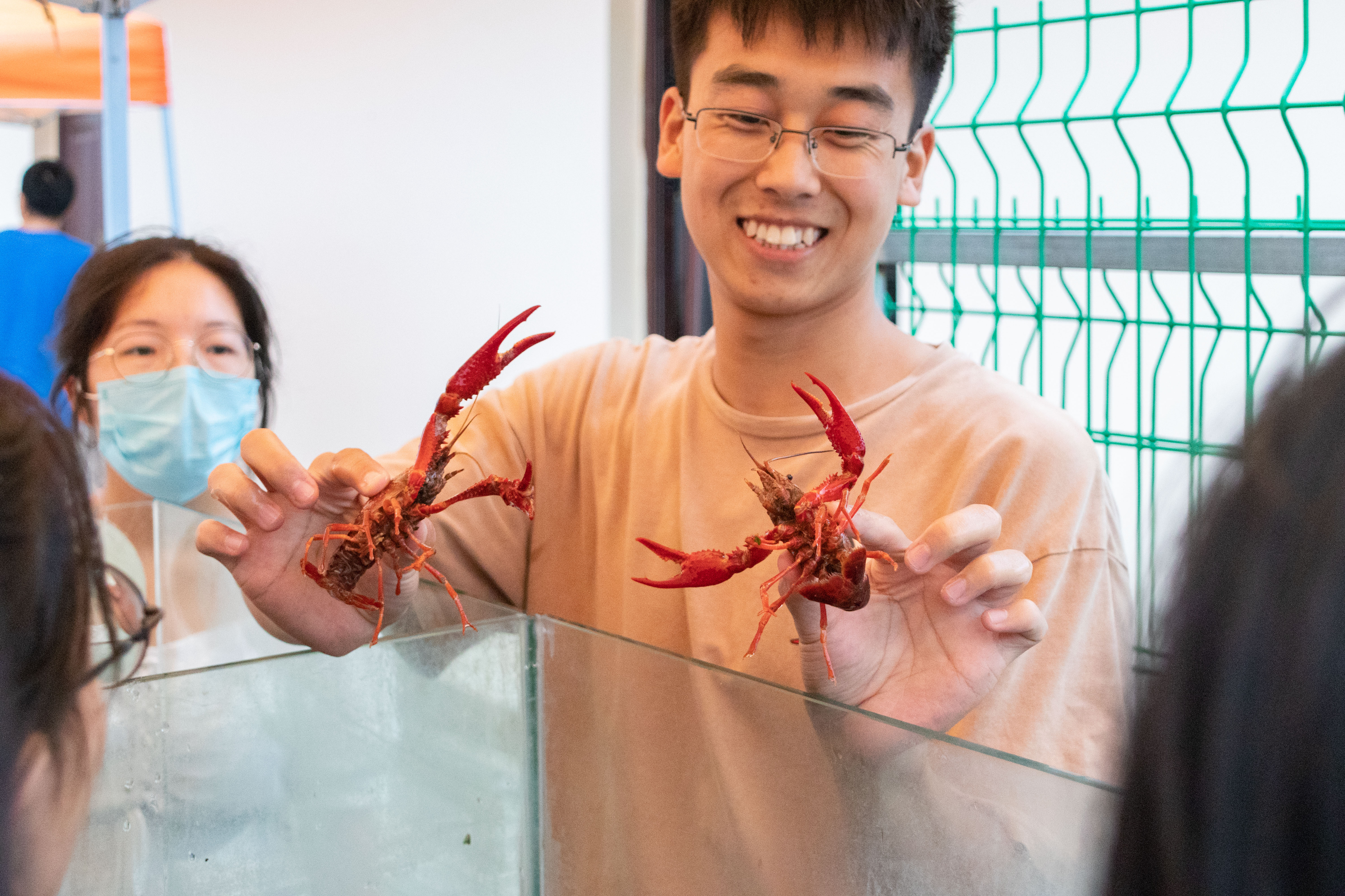 亚博全站APP登录官网19级研究生杨伟杰向新生讲解如何辨别小龙虾雌雄（学通社记者 周丹丹 摄）